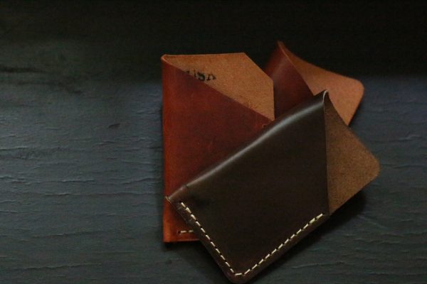 Dark and moody flatlay of minimalist wallets.