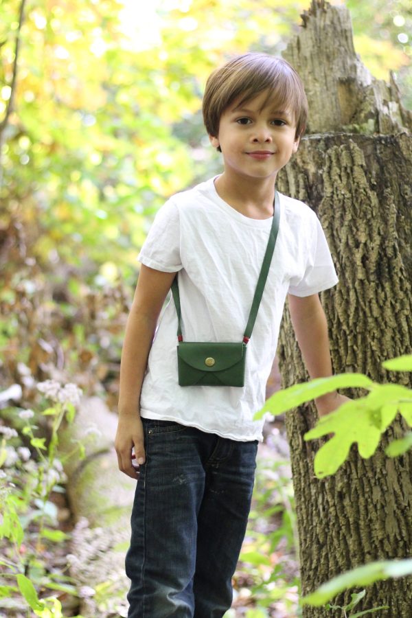 Little boy in the woods with his leather pouch.